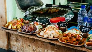 Colorful street food dishes on display at Greenwich Food Market in London, highlighting diverse cuisines.